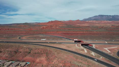 traffic on american i-15 highway and church rocks red sandstone formations by hurricane utah usa, drone aerial view