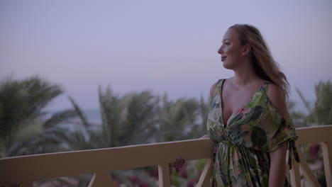 young woman on a balcony staring at the distant and enjoy the windy at afternoon