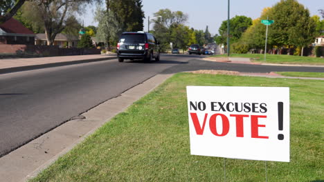 Election-Voter-Rally-Sign-Next-to-Road-with-Cars-Driving-By,-No-Excuses-Vote