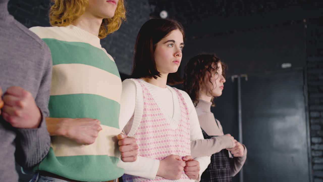 팔을 잠근 채 서있는 장벽을 형성하는 젊은 시위자들의 폐쇄