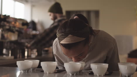female barista sniffing different types of coffee