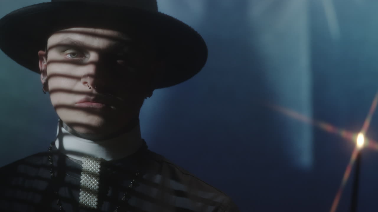 Young Man in Priest Costume Posing in Dark Room