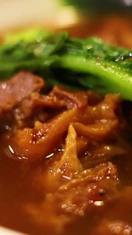 delicious noodle soup with meat and greens