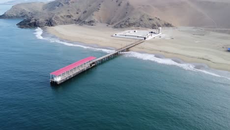 imágenes de drones de paralaje de un muelle en perú y la playa y las montañas