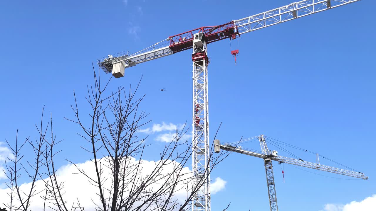 푸른 하늘, 모션 뷰에 고립 된 키가 큰 철강 건설 크레인의 커플