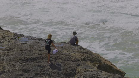 two people on rocks by the ocean