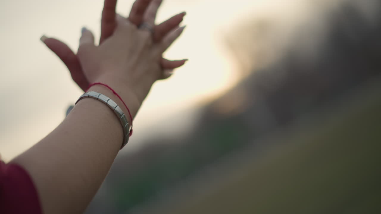 CloseUp Hands Reaching Toward Sunset Outdoors. Extended Fingers And Gentle Clasping, Manicured Nails And Layered Bracelets, Warm Golden Glow, Soft Bokeh Background, Contemplative Mood And Peaceful