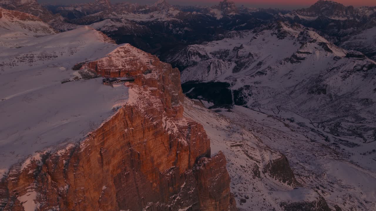 Valle montuosa innevata nelle Dolomiti al tramonto. Vista drone