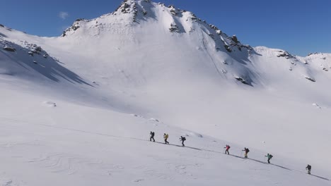 group of alpinists climbing a snowy mountain slope