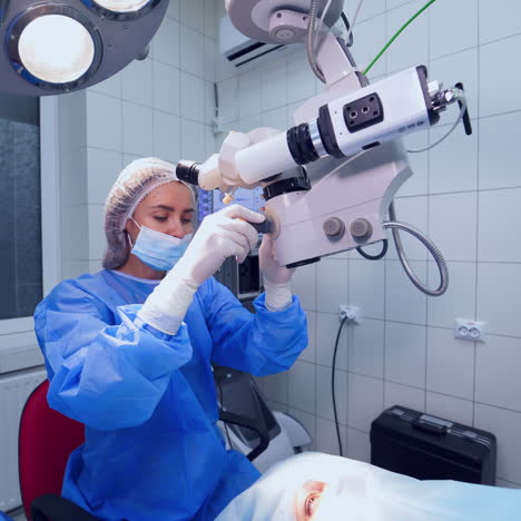surgeon performs the operation in latex gloves and mask with microscope. doctor in medical uniform works with microscope to treat patient's eyes in the light room.