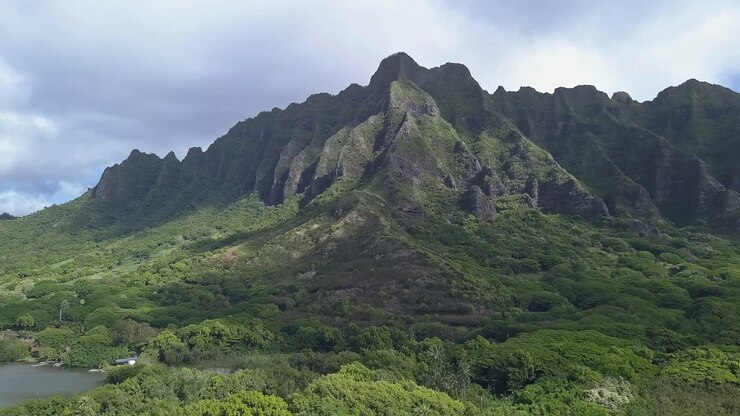 Aerial view of Kualoa mountains in Oahu with blue sky and clouds