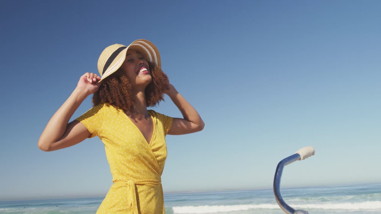 모자를 입고 자전거를 타고 바 ⁇ 가에 있는 아프리카계 미국인