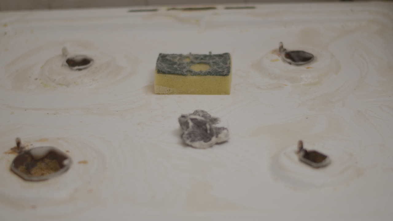 наклон к изношенной губке, лежащей на очищенной кухонной плите