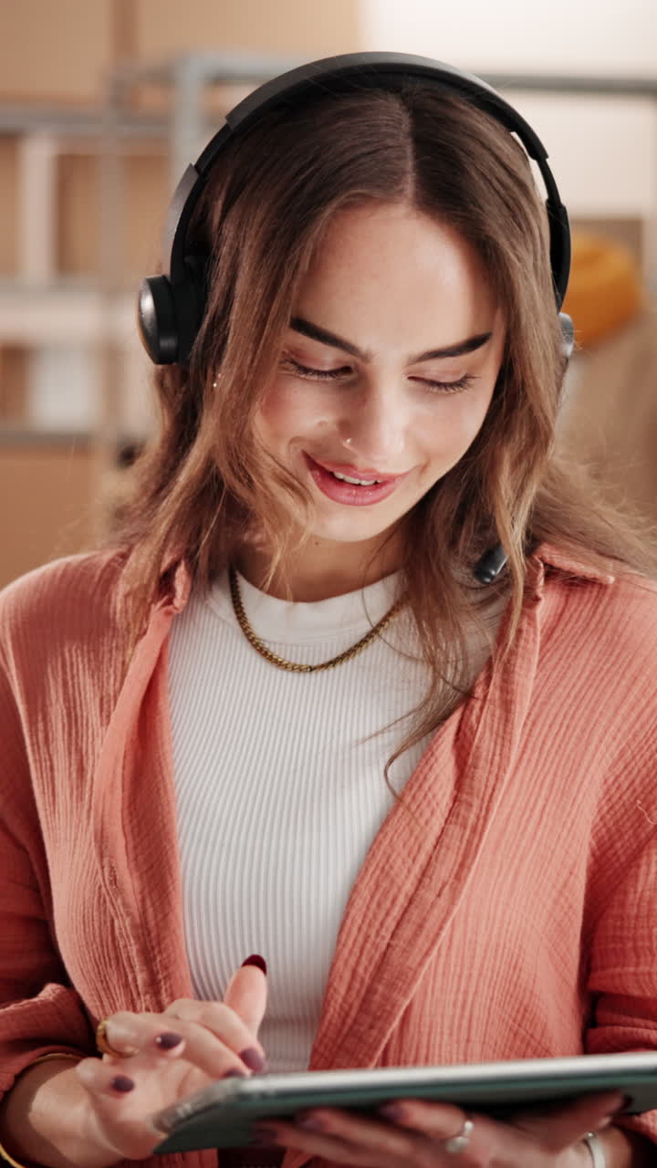 Mujer joven con auriculares trabajando en una tablet en un almacén