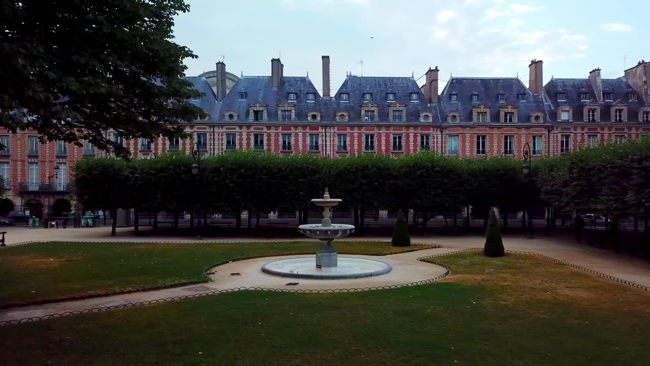 place des vosges에 있는 빨간색 정면 집 앞의 분수와 린든 나무의 전망