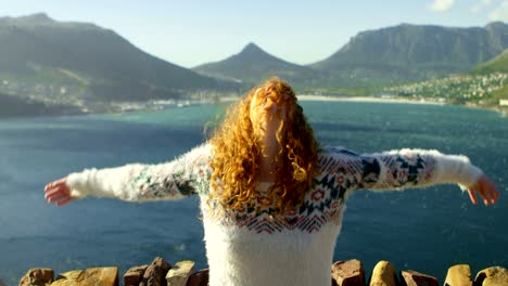 woman standing with arms outstretched near a sea 4k