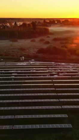 early misty morning sunrise with solar panels, aerial vertical view
