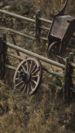 old wooden wheel and rusty wheelbarrow in a garden