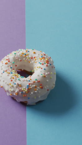 video de una rosquilla con glaseado sobre fondo púrpura y azul