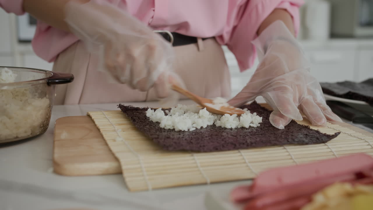 Anonymous Woman Placing Rice on Nori for Kimbap