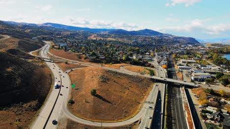 dolly out drone shot hyperlapse de kamloops bc canada con puentes y la autopista 1 y la autopista yellowhead 5 en un día soleado en la ciudad del desierto con autos y camiones conduciendo en primer plano
