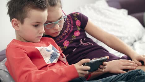 Niños-En-Edad-Preescolar-Jugando-Juegos-En-Teléfonos-Inteligentes.-Niños-Jugando-Con-El-Teléfono-Móvil