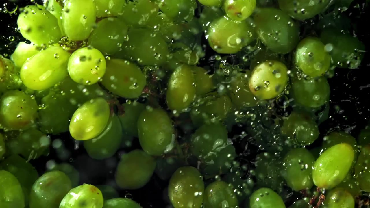 Close-up de Uvas Verdes Sendo Lavadas em Água Limpa com Bolhas