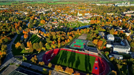 aerial view of dobele castle, sports complex, and city landscape in autumn season