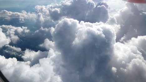 fliyng-fast-trough-some-thick-white-clouds,-view-from-airplane-window