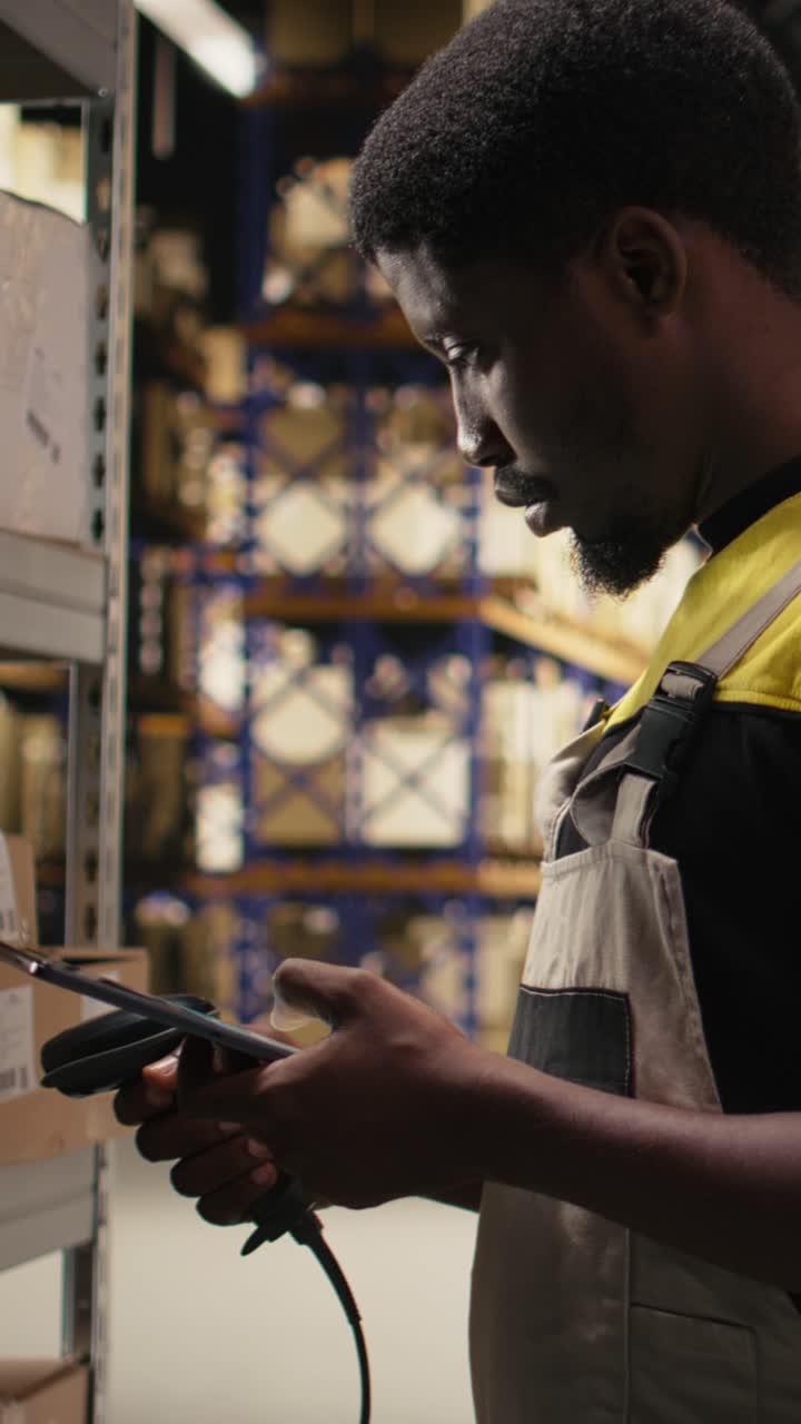 Vertical Video Black male worker using scanner checking airway bill numbers in inventory