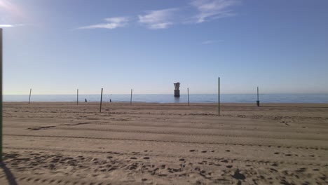 Aerial-view-of-empty-beach-in-Marbella,-Spain,-moving-into-the-sea