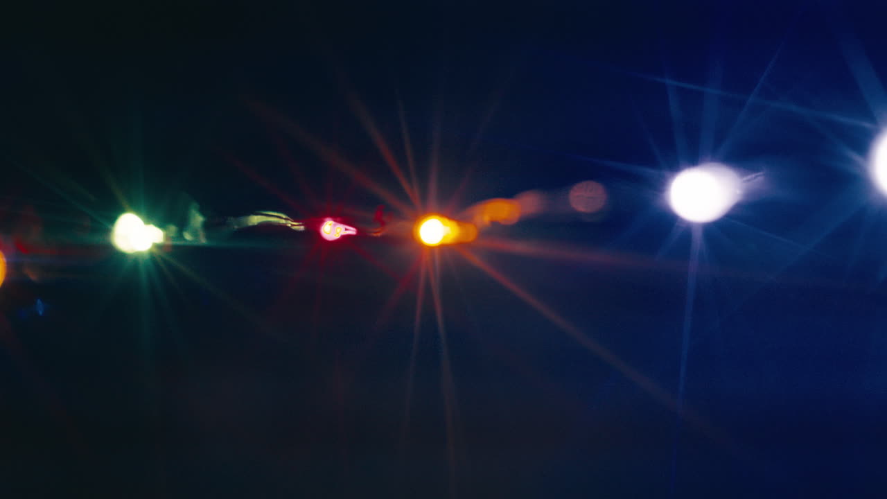 Flashing Christmas lights in front of a dark background