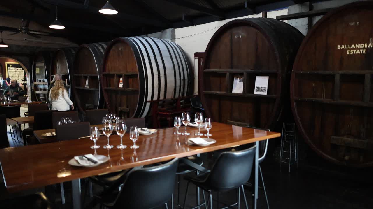 Elegant wine glasses arranged on wooden table in dimly lit winery cellar dining environment