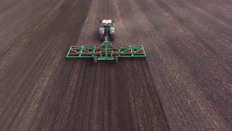 agrobusiness - tractor running in the field in the spring 1