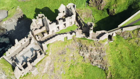 aerial pan left shot of the now-ruined dunluce castle, its walls and halls