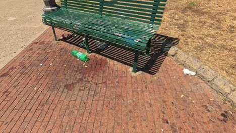 empty bench with litter in a sunny park