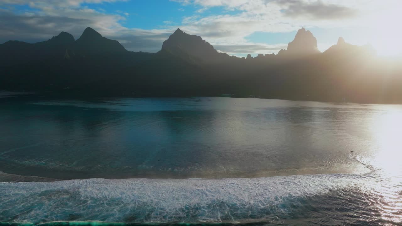 Nascer do sol matinal, céu azul, brilho solar, Ilha Moorea, Baía de Opunohu, Polinésia Francesa, drone aéreo, lagoa, recife de coral, picos irregulares do Monte Mauaroa, Tohivea, Rotui, Haapiti, Paopao, Oceano Pacífico, vista para cima.