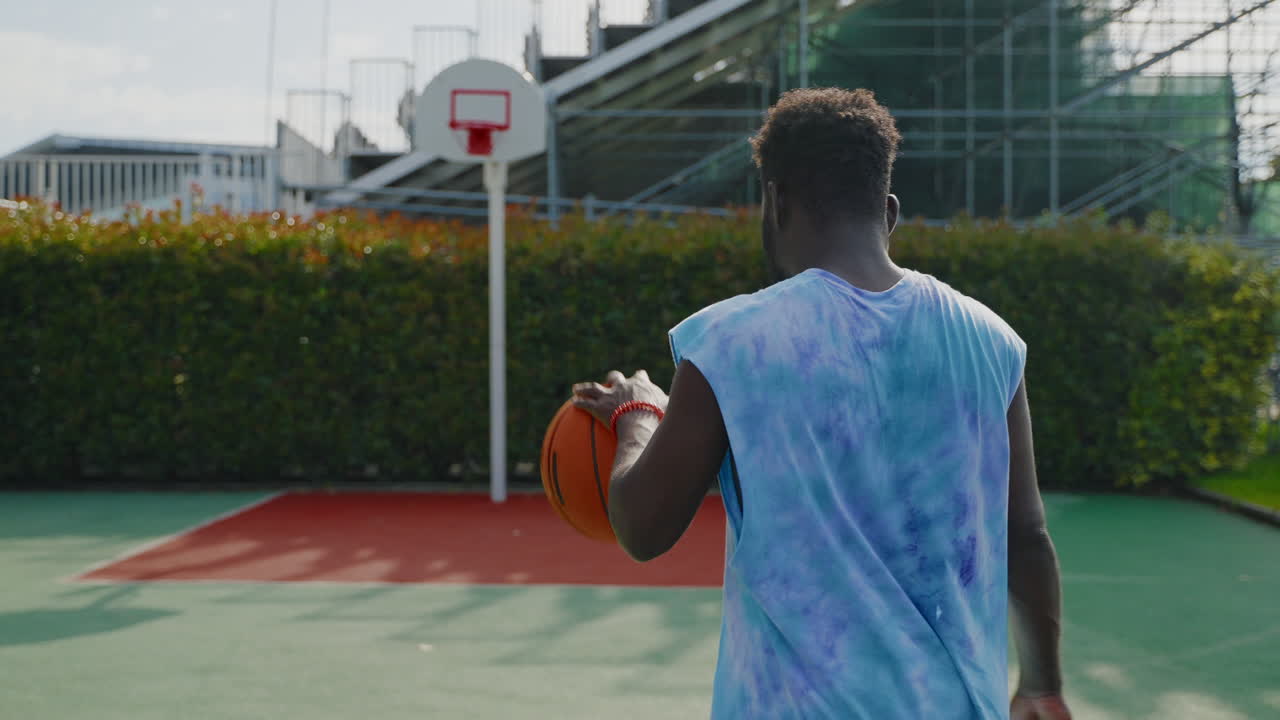 hombre sosteniendo baloncesto en la cancha al aire libre