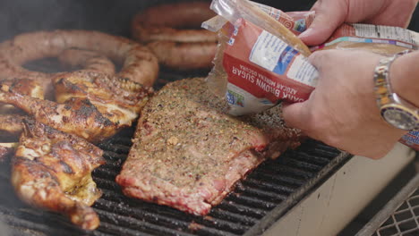 brown sugar being poured on to bbq pork ribs to make a glaze