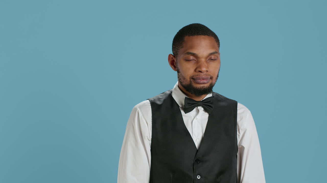 슈트 와 타이 를 입고 호텔 손님 들 에게 손을 흔들고 있는 친절 한 펠리맨 포터