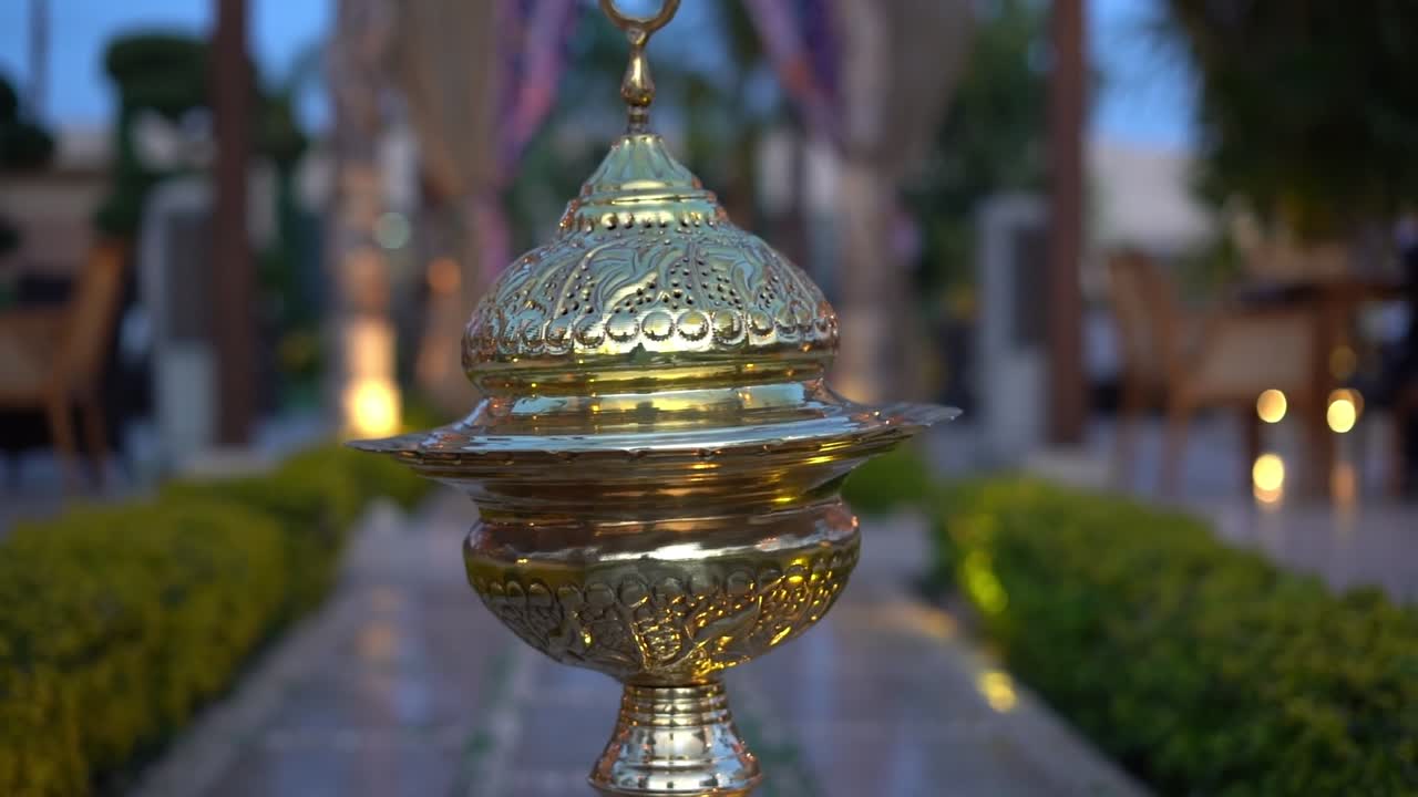 A traditional decorative lantern with Islamic motifs and a crescent moon on top, close up shot