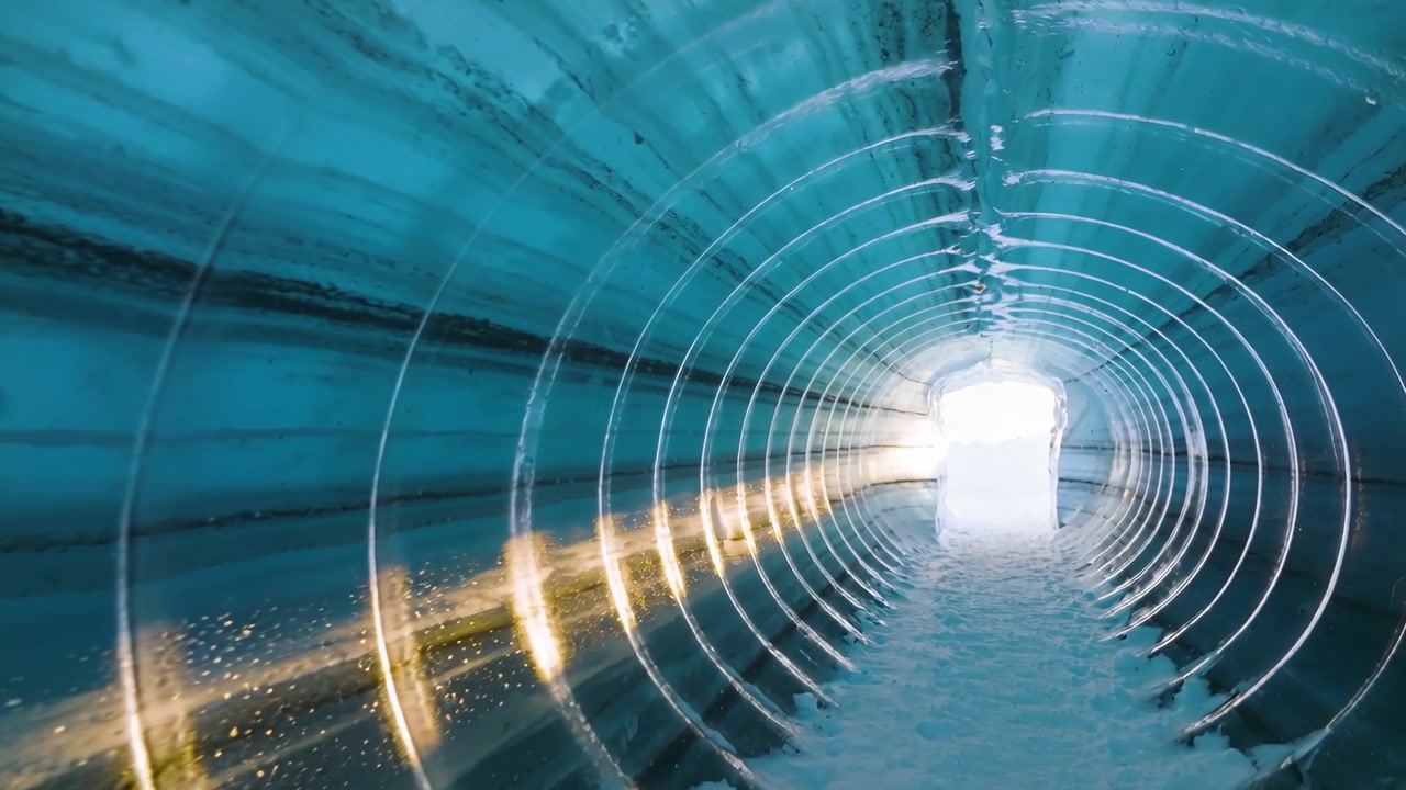 Avvio della riproduzione, telecamera in tubo scanalato che si muove verso un'uscita rettangolare, con neve e scintille dorate