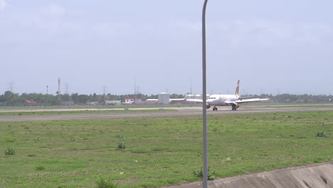 the atmosphere of the runway at yogyakarta international airport, a commercial super air jet aircraft is seen landing.