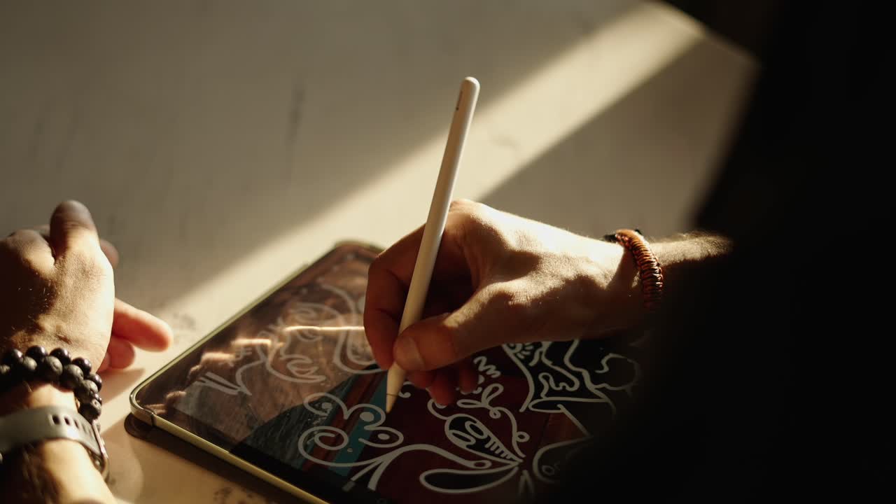 Nærbillede af en person der tegner digital kunst på en tablet med en stylus.
