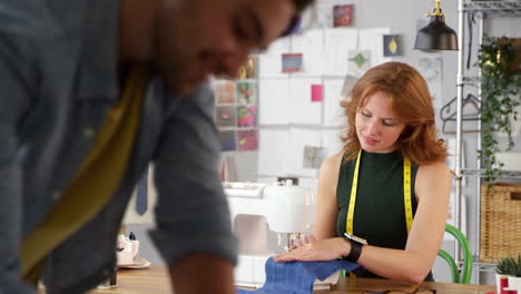 male and female clothes designers working in fashion studio together