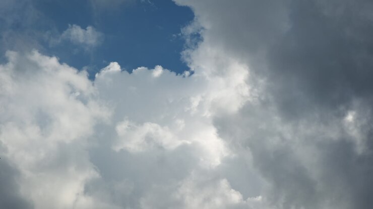 Summer clouds time lapse against blue sky and sun rays