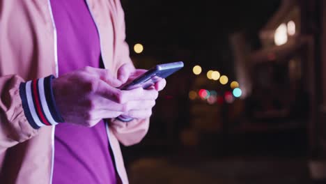 Caucasian-male-talking-on-the-phone-in-the-evening-with-lights-in-the-background