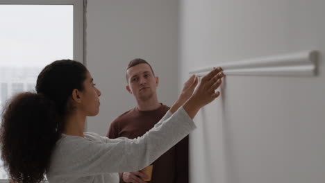 couple installing crown molding on white wall