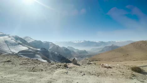 wide shot of himalayas mountains valley cinematic camera zoom in or out at running car.