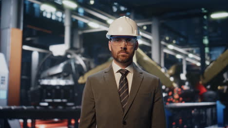 portrait factory owner posing in production workshop. serious engineer standing